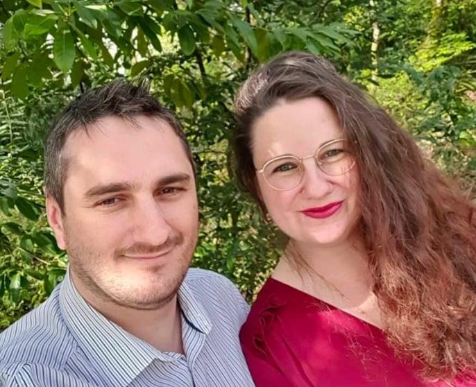 Bárbara y Kevin sonriendo a la sombra de un árbol.